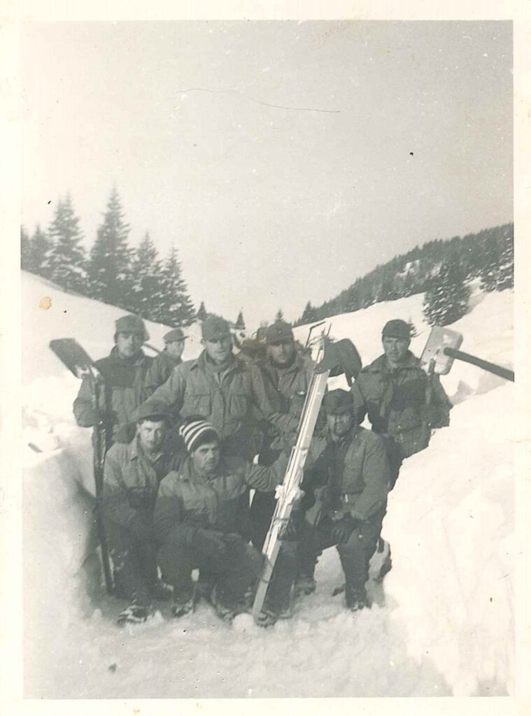 Artiglieri alpini della 50ª Batteria con i badili in una trincea di neve fra gli abeti sull’altopiano di Asiago, gennaio 1965