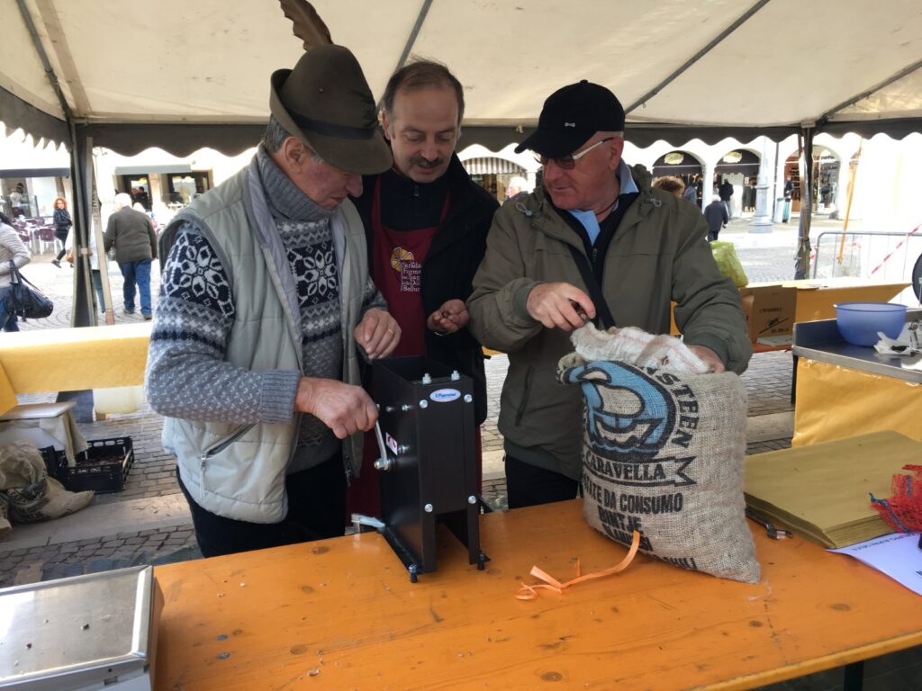 From left: Toni Tamburlin, Andrea Dal Pont and Ennio Pavei at the chestnut table, with the automatic machine for scoring them.